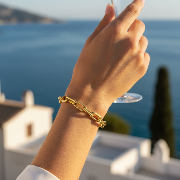 Close-up of woman wearing gold paperclip bracelet in Italy by the sea